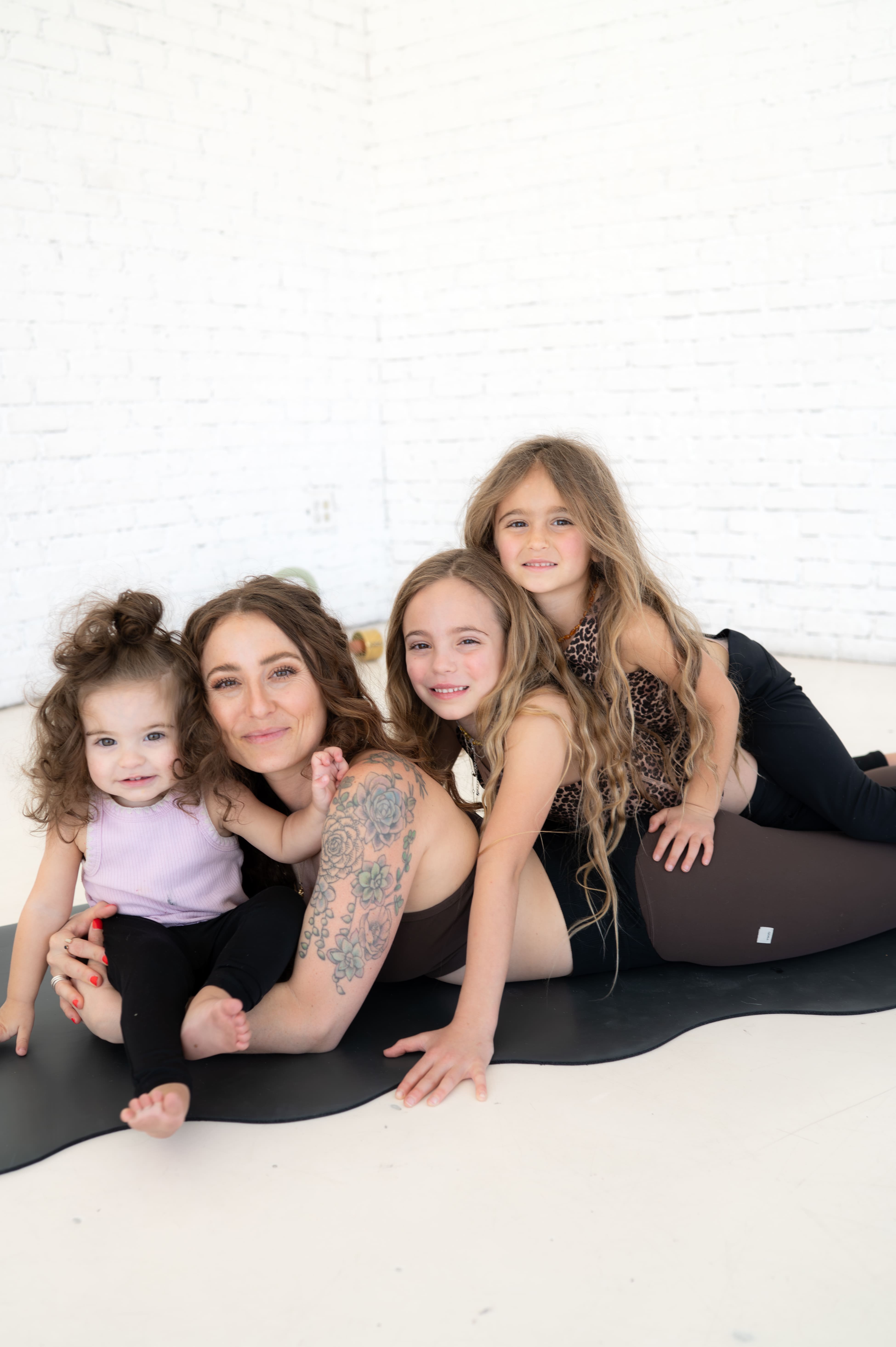 Jesse Truelove with her daughters in a bright yoga studio